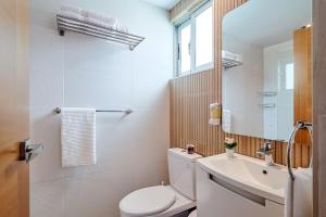 a bathroom with a toilet and a sink and a mirror at Comfy 1BR Apt, Centric Full AC in La Julia +24 photos