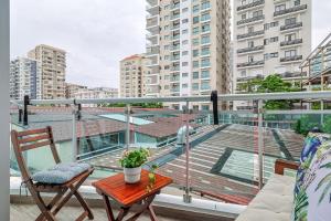 a balcony with a table and chairs on a building at Comfy 1BR Apt, Centric Full AC in La Julia