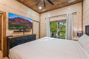 ein Schlafzimmer mit großem Bett und Fenster in der Unterkunft Rustic RidgeView Hot Tub Grill Foosball More in Cove Creek Cascades