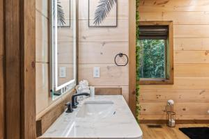 ein Badezimmer mit Waschbecken und Spiegel in der Unterkunft Rustic RidgeView Hot Tub Grill Foosball More in Cove Creek Cascades + 52 Fotos
