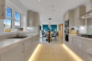 een keuken met witte kasten en een eetkamer bij Sunrise View - North East Escapes in Long Houghton