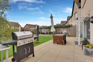 een achtertuin met een barbecue en een tafel bij Sunrise View - North East Escapes in Long Houghton