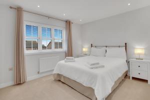 een witte slaapkamer met een groot bed en een raam bij Sunrise View - North East Escapes in Long Houghton +27 foto's