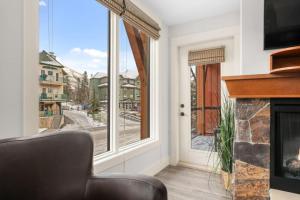 uma sala de estar com lareira e uma janela em Mountain Escape 2BR Hot tub and Pool Near Banff em Canmore