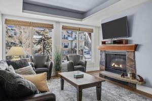 uma sala de estar com lareira e televisão em Mountain Escape 2BR Hot tub and Pool Near Banff em Canmore mais 45 fotografias