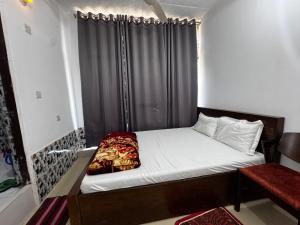 a small bed in a room with a window at Hotel Tayef Zigatola in Dhaka