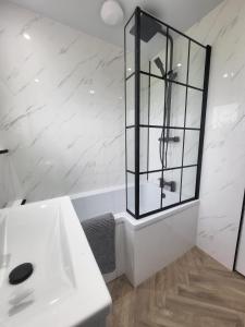 a bathroom with a white sink and a glass cabinet at The MacIntyre - Coorie Doon Stays in Kilmarnock +4 photos