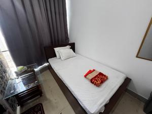 a small bedroom with a small bed with white sheets at Hotel Tayef Zigatola in Dhaka