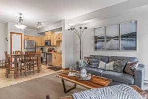 una sala de estar con un sofá y una mesa en Chic 1BR City Nest Heated Parking and Hot Tub and Pool, en Canmore