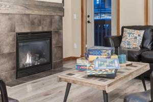een woonkamer met een open haard en een salontafel bij 3BR Rockies Condo Heated Pool and Hot Tub in Canmore +31 foto's