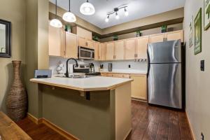 a kitchen with a stainless steel refrigerator and wooden cabinets at Spacious Getaway near Banff with Heated Pool in Canmore
