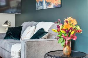 a vase of flowers on a table in front of a couch at Lovely 2BR Canmore Condo w Heated Pool and Hot Tub in Canmore