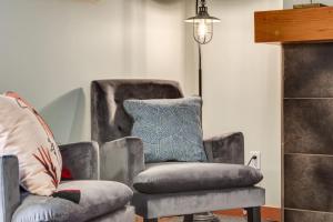 a chair and a recliner in a living room at Lovely 2BR Canmore Condo w Heated Pool and Hot Tub in Canmore +24 photos