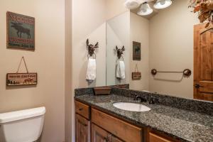 a bathroom with a sink and a toilet and a mirror at Twin Lift Lodge in Big Sky Mountain Village