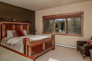 a bedroom with a wooden bed and a window at Twin Lift Lodge in Big Sky Mountain Village