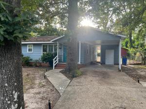 a blue house with a tree in front of it at Minimalist-Modern Home with Keyless Entry and Parking in Fayetteville