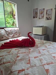 a red umbrella laying on a bed in a room at cantinho da Raq,um quarto SUÍTE com ar condicionado duas camas de casal perto doAeroporto, UEPA, Rodoviaria, magueirao, UFPA,parque ambiental, in Belém