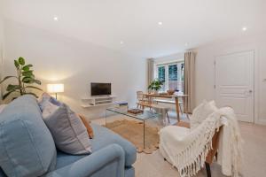 Una sala de estar con un sofá azul y una mesa. en Modern home in Sunninghill, en Ascot