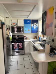 a kitchen with a stove and a refrigerator at Charming room in artist studio and Gallery in Santa Clarita