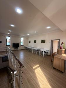a large room with tables and chairs and a television at Hostel in Tashkent
