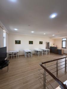 a room with tables and chairs and a flat screen tv at Hostel in Tashkent +19 photos