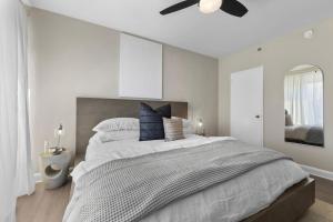een slaapkamer met een groot bed met een plafondventilator bij Elevated Minimalist Escape - Free Parking and Metro - The Sutton in Radnor Heights