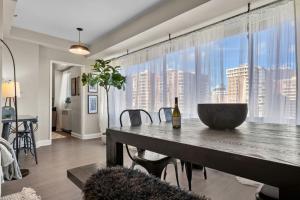 een eetkamer met een tafel en een groot raam bij Elevated Minimalist Escape - Free Parking and Metro - The Sutton in Radnor Heights