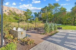 een tuin met tafels en stoelen en een gebouw bij Elevated Minimalist Escape - Free Parking and Metro - The Sutton in Radnor Heights