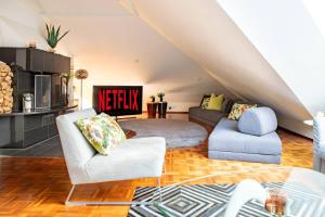 a living room with two chairs and a couch at Penthouse Loft with Jacuzzi and Sauna in Helsinki