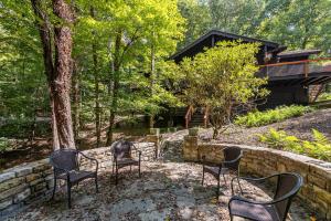a group of chairs sitting next to a stone wall at Elk Watch at Hound Ears in Valle Crucis