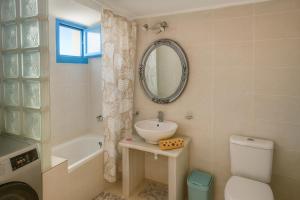 Un baño con lavabo, inodoro y espejo. en 1 Bed Apt - Sleeps 2 - Free Parking - Sea View, en Masouri