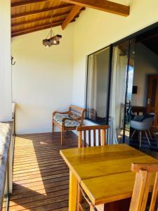 a living room with a table and chairs on a deck at Chalés Terras Altas in Gonçalves +86 photos