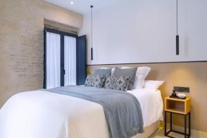 a bedroom with a large bed with white sheets and pillows at Luxury Apartment overlooking Casa Pilatos in Seville