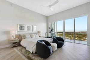 a bedroom with a large bed with black chairs at Ultra-luxury Coastal Retreat in Pompano Beach