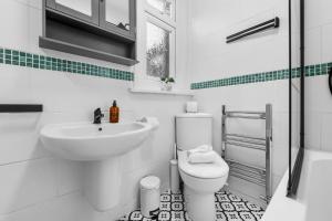 ein weißes Badezimmer mit Waschbecken und Toilette in der Unterkunft 3-Bedroom Stunning, Cosy, Luxurious House in Fratton, Sleeps 8 with Parking, Pet-Friendly - LONG TERM STAY SPECIAL OFFER AVAILABLE! - by Blue Puffin Stays in Portsmouth + 50 Fotos