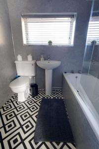 a bathroom with a sink and a toilet and a tub at Comfy 1BR Apt, Self Check In, Free Parking by The Davis Collective in Derby