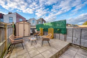 eine Terrasse mit Stühlen und einem Tisch auf einem Balkon in der Unterkunft 3-Bedroom Stunning, Cosy, Luxurious House in Fratton, Sleeps 8 with Parking, Pet-Friendly - LONG TERM STAY SPECIAL OFFER AVAILABLE! - by Blue Puffin Stays in Portsmouth