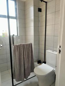 ein weißes Badezimmer mit Toilette und Dusche in der Unterkunft Kitisuru Zen Stay in Gatunga