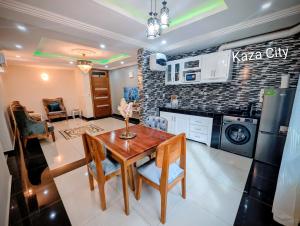 a kitchen and dining room with a wooden table in a room at KAZA City in Bafoussam
