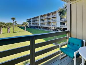 a balcony with a chair and a building at Lighthouse Point by Tybee Vacation Rentals in Tybee Island
