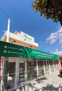 a building with a green awning in front of it at Pousada Pura Vida in Bertioga