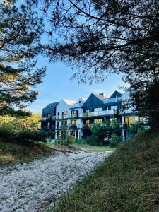 a large building on a beach with trees at Apartament na wydmie B9 in Łeba