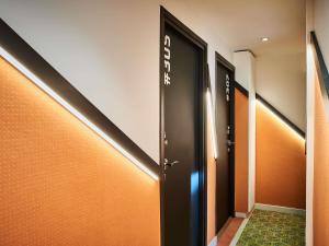 a row of elevators in a hallway with orange walls at Greet Boulogne Billancourt Paris in Boulogne-Billancourt