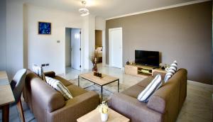a living room with two couches and a flat screen tv at Le Basilic Hotel Apartment & Spa in Addis Ababa