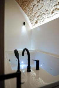 a sink with two faucets in a kitchen at Myra Bari Bed & Spa in Bari +14 photos