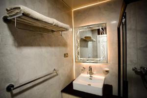 a bathroom with a sink and a mirror at Le Basilic Hotel Apartment & Spa in Addis Ababa +15 photos