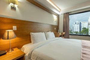 a hotel room with a bed and a window at Weston Suites Hotel in Santo Domingo