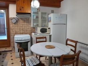 a kitchen with a table and a white refrigerator at Oustal marcellin in Fanjeaux