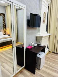 Cette chambre comprend un miroir et un bureau avec une télévision. dans l'établissement City Inn Boutique Hotel, à Baku