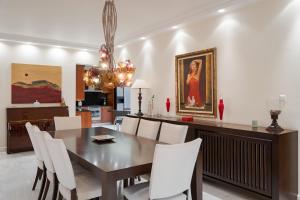 a dining room with a table and white chairs at Voula Riviera Apartment in Athens
